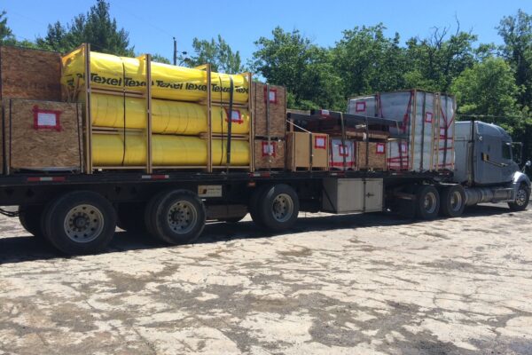 Flatbed truck loaded with yellow and wooden crates.