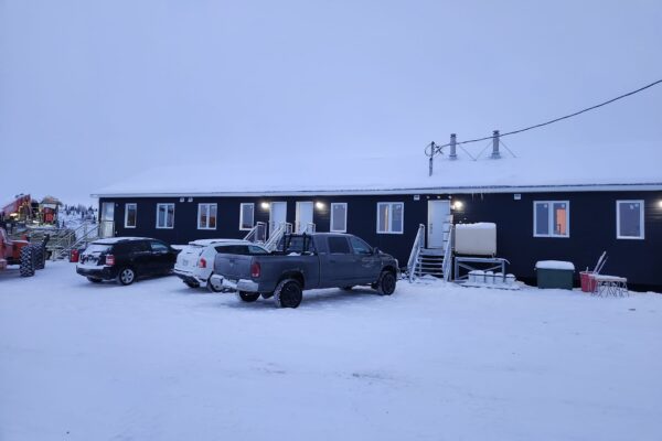 Snow-covered building with parked cars