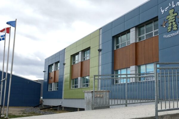 School building with colorful flags flying high.