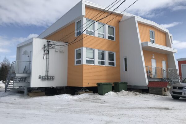 Modern orange building in snowy landscape.