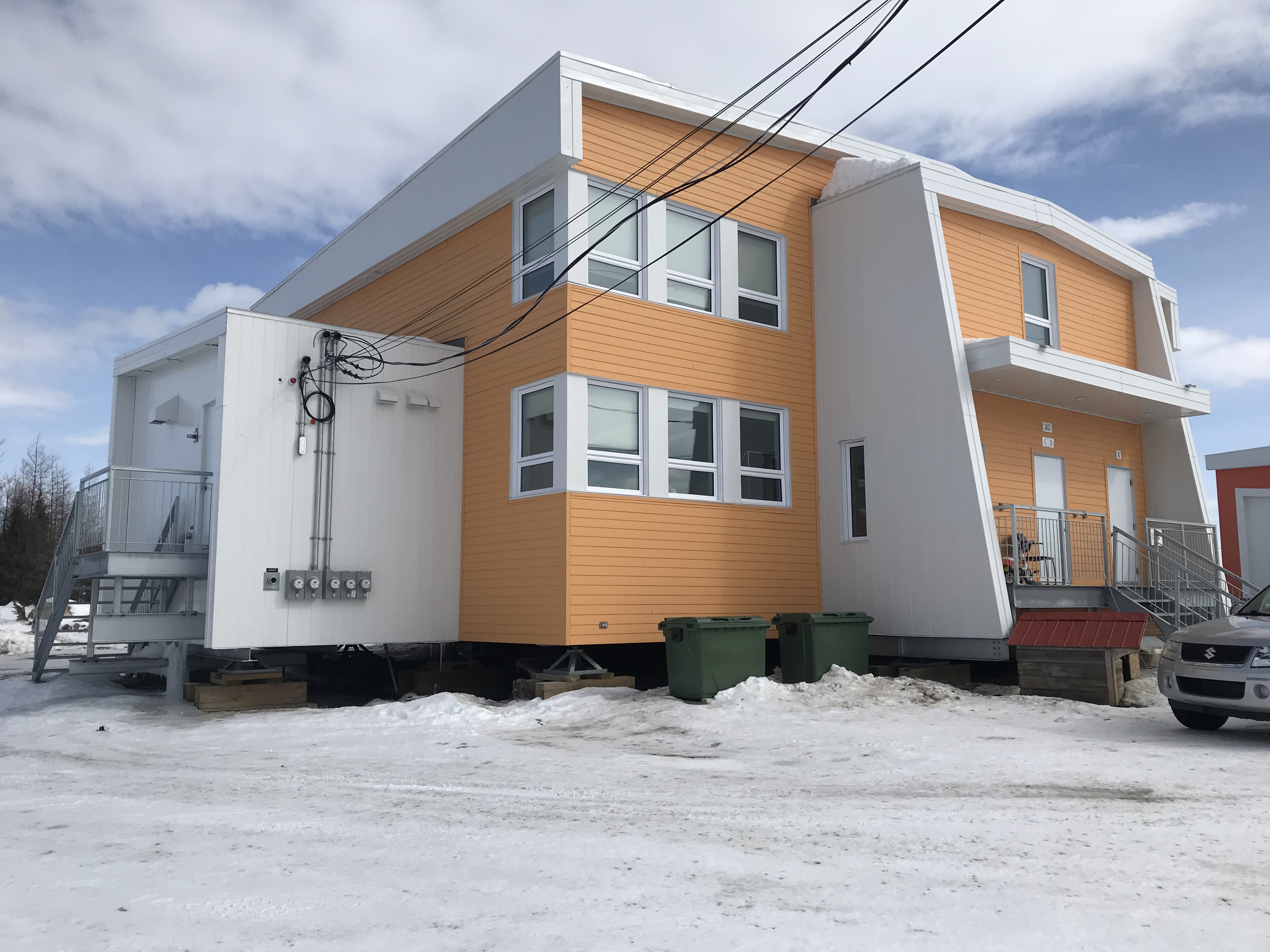 Modern orange building in snowy landscape.