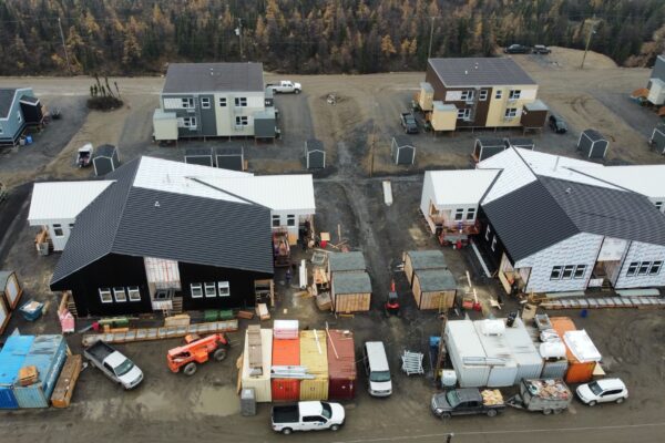 Aerial view of construction site with houses and vehicles.