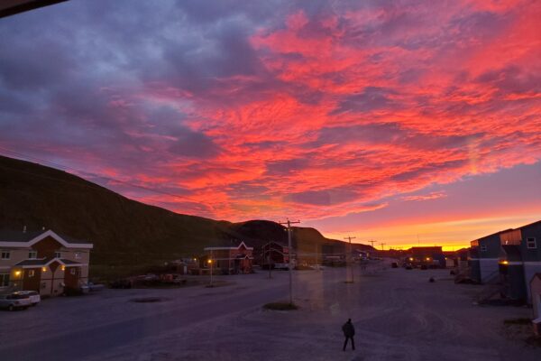Vibrant sunset over quiet town street scene.